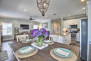 Enjoy cooking and dining in this well-equipped kitchen with a central island, refrigerator, and microwave.