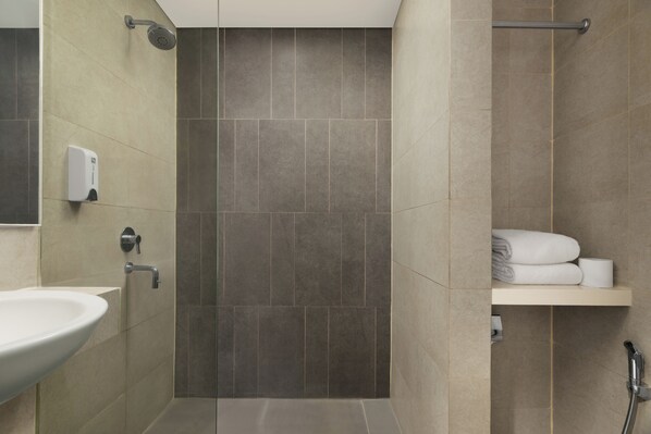 A bathroom with a sink, a shower, and a towel rack. - Swiss-Belexpress Cilegon (Cilegon)
