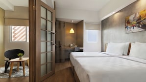 Una habitación de hotel con cama, escritorio, silla y ventana.