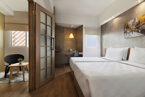 A hotel room with a bed, desk, chair, and a window. - Swiss-Belexpress Cilegon (Cilegon)