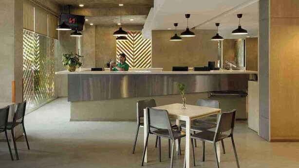 Un moderno vestíbulo de hotel con mostrador de recepción, zona de estar y diseños decorativos en la pared.