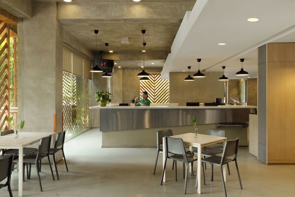A modern interior with a reception desk, seating area, and a herringbone-patterned wall.