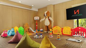 A room with a mascot, a basketball hoop, colorful play structures, and a Swiss-Belexpress sign.