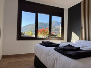 Enjoy a peaceful retreat with a mountain view from this serene bedroom featuring a comfortable bed and stylish decor.