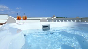 Un jacuzzi con dos bebidas en una terraza.