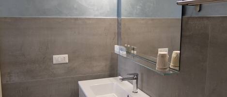 Une salle de bain moderne avec un lavabo blanc, un miroir et des toilettes.