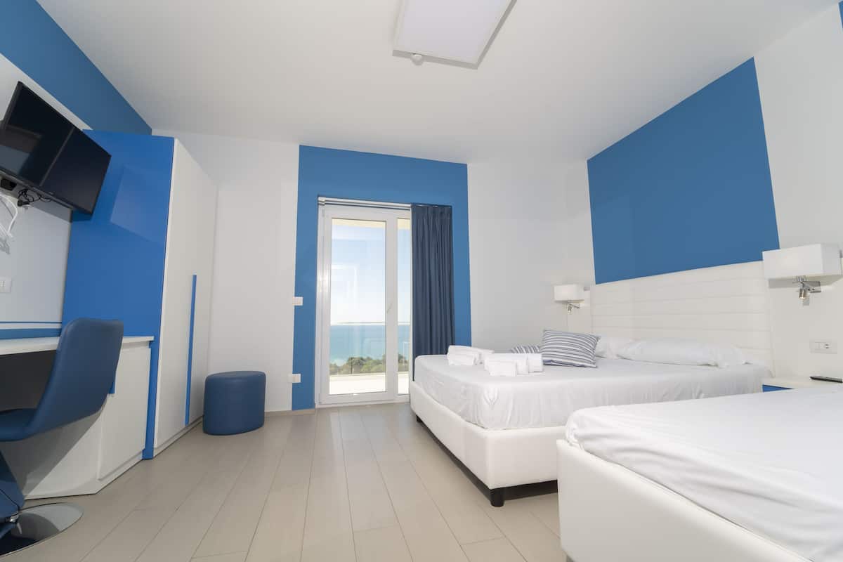 A modern hotel room with a bed, a desk, and a chair.
