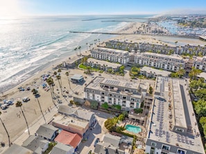 A coastal hotel with multiple buildings, a beach, and a marina.