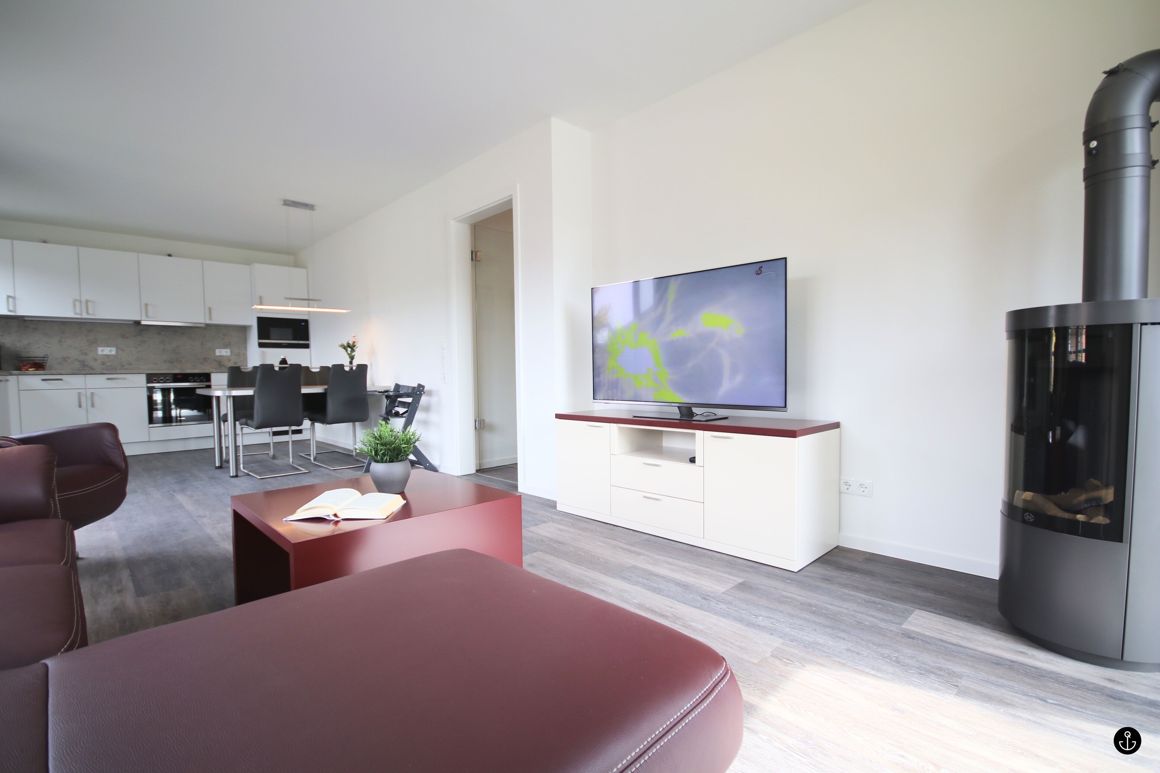 A modern living room with a flat-screen TV, a fireplace, and a dining area with a table and chairs.