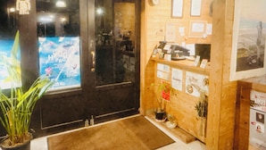 Una zona de recepción con un escritorio de madera, un reloj y cuadros en la pared.
