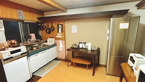 Una cocina con armarios de madera, un refrigerador de acero inoxidable, un microondas y una estufa.