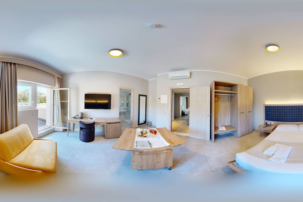 Une chambre d’hôtel moderne équipée d’un lit, d’un canapé, d’un bureau et d’une armoire.