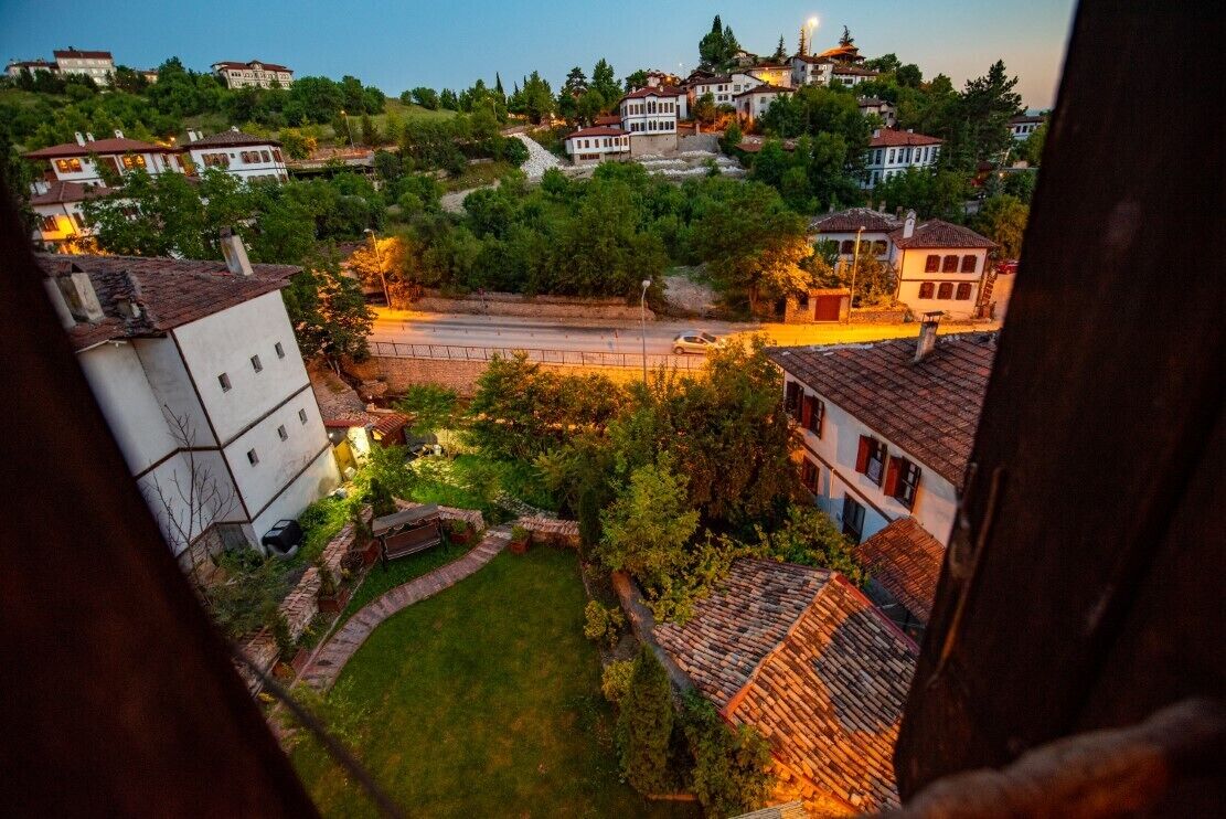 Zona residencial numa encosta, com casas, uma estrada e um pequeno jardim.