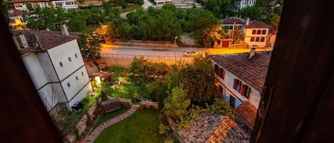 Zona residencial numa encosta, com casas, uma estrada e um pequeno jardim.