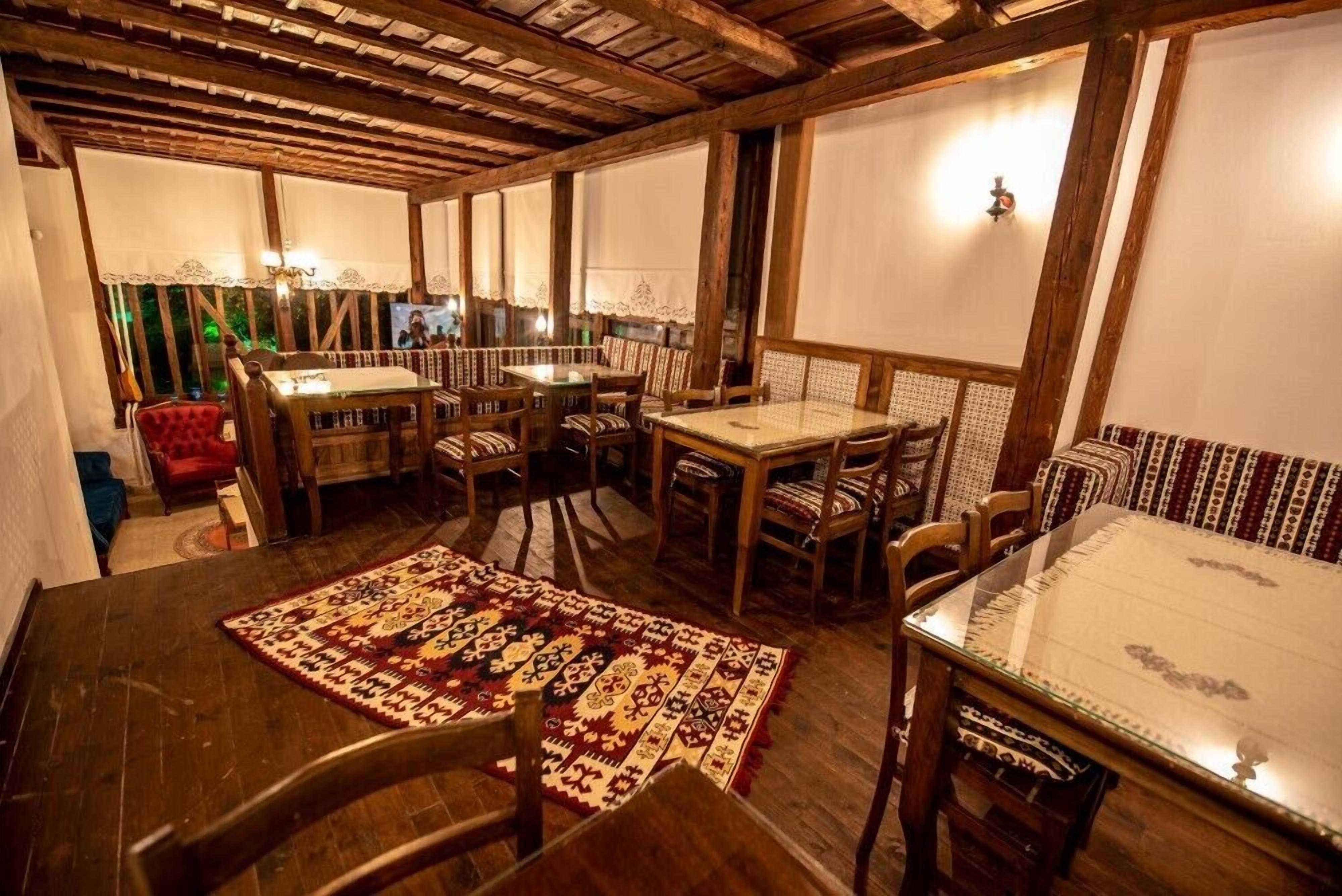 A cozy dining area with wooden furniture and patterned rugs.