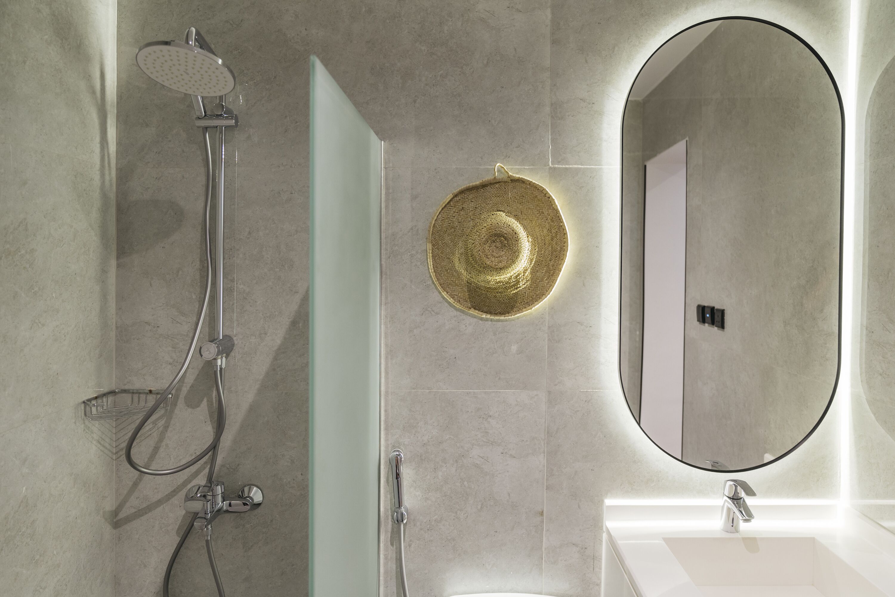 A modern bathroom with a shower, a sink, and a large mirror.