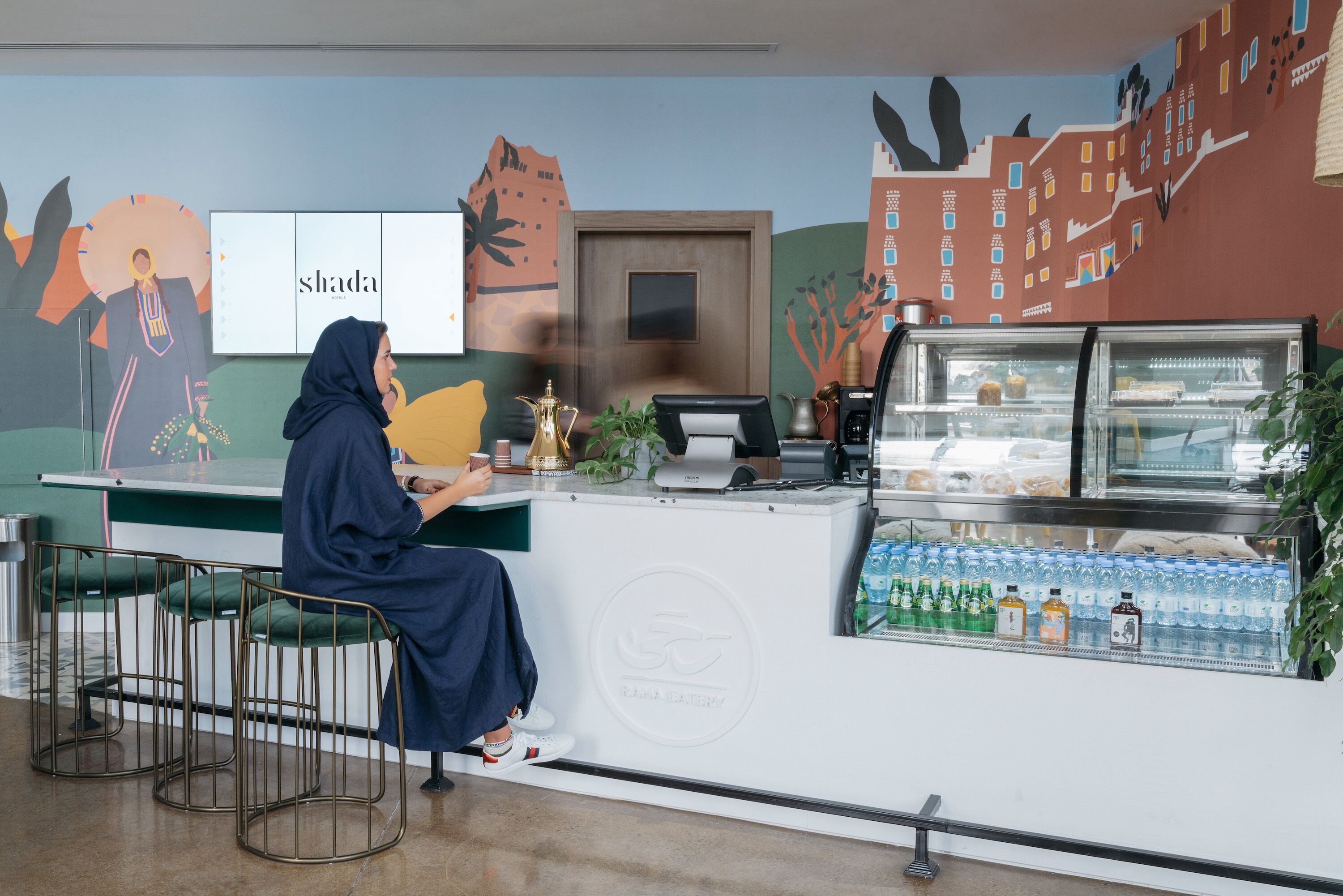 A counter with a beverage dispenser and seating area.
