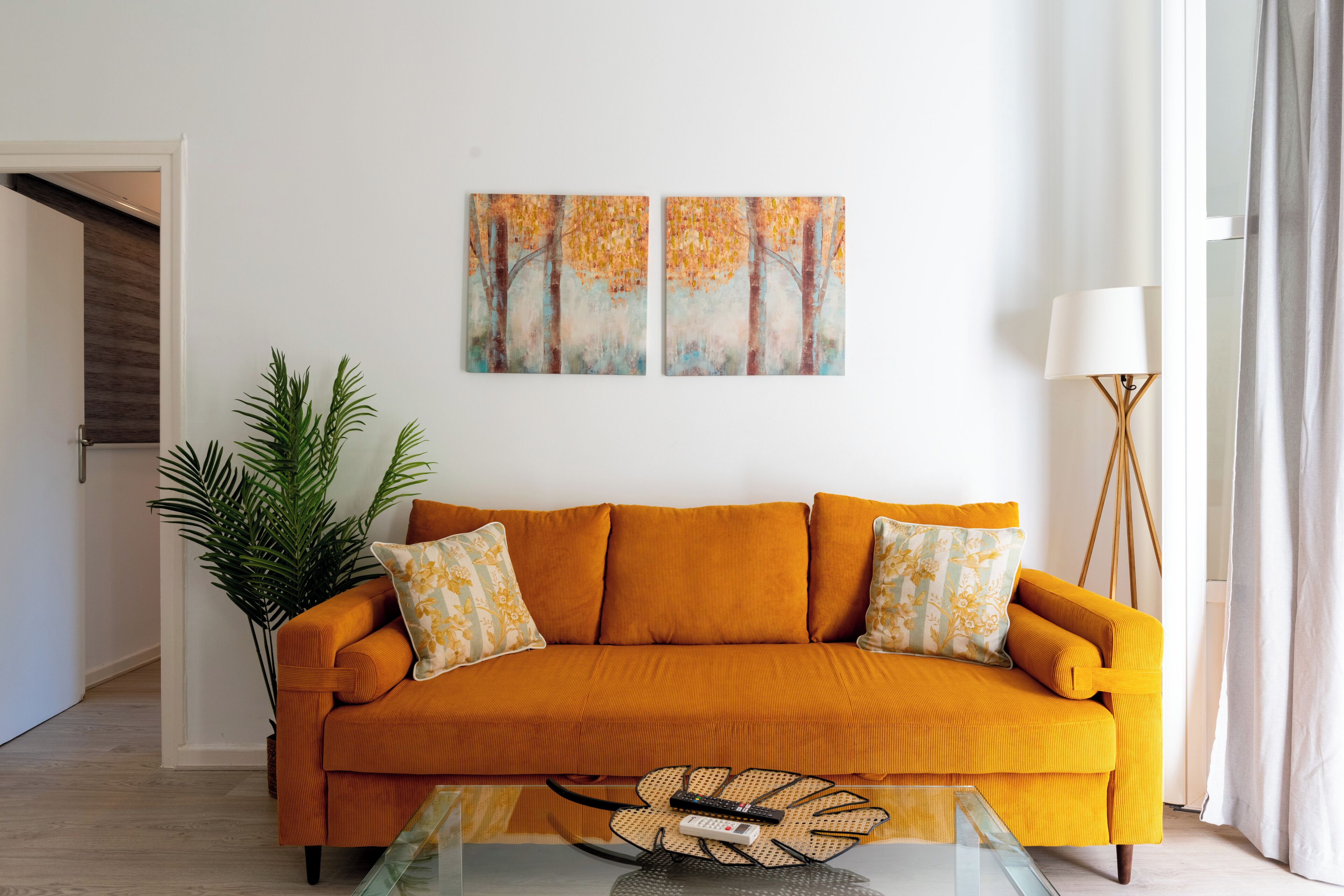 A living room with a sofa, a coffee table, a lamp, and a painting on the wall.