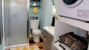 Un bagno piccolo ma funzionale, con doccia, WC e lavatrice.