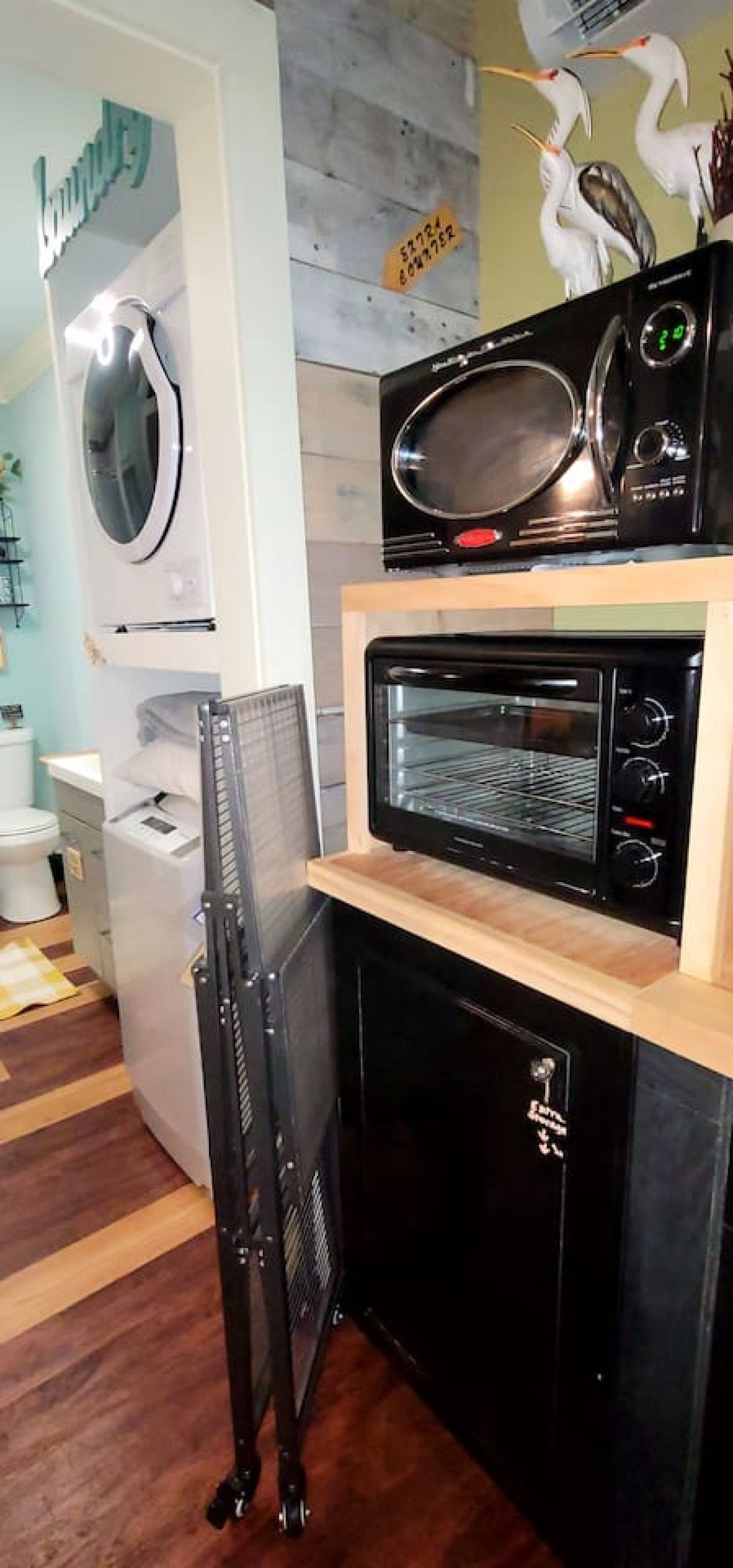 Une cuisine compacte équipée d’un four à micro-ondes, d’un four traditionnel et d’un égouttoir.