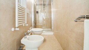 A modern bathroom with a glass-enclosed shower, a toilet, and a sink. - Palazzo Marigliano - Don Aniello (Napoli)