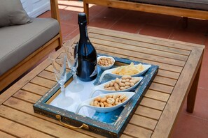 Ett bricka med snacks och en flaska vin på ett träbord.