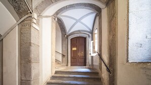 A stone staircase leading to a wooden door with a white ceiling above. - Don Francesco: an apartment with spectacular views in Palazzo Marigliano (Napoli)