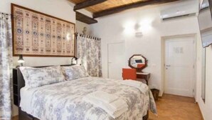 Een slaapkamer met een bed, een wandklok en een deur.