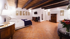 A bedroom with a bed, desk, chair, and a TV on the wall. - Palazzo Marigliano - Don Pio (Napoli)