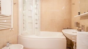 A modern bathroom with a glass-enclosed shower, a white bathtub, a sink, and a toilet. - Palazzo Marigliano - Don Pio (Napoli)