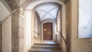 Un escalier avec des murs en pierre et une porte en bois en haut.