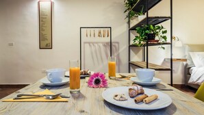 Una mesa de desayuno con platos, tazas y vasos de jugo.