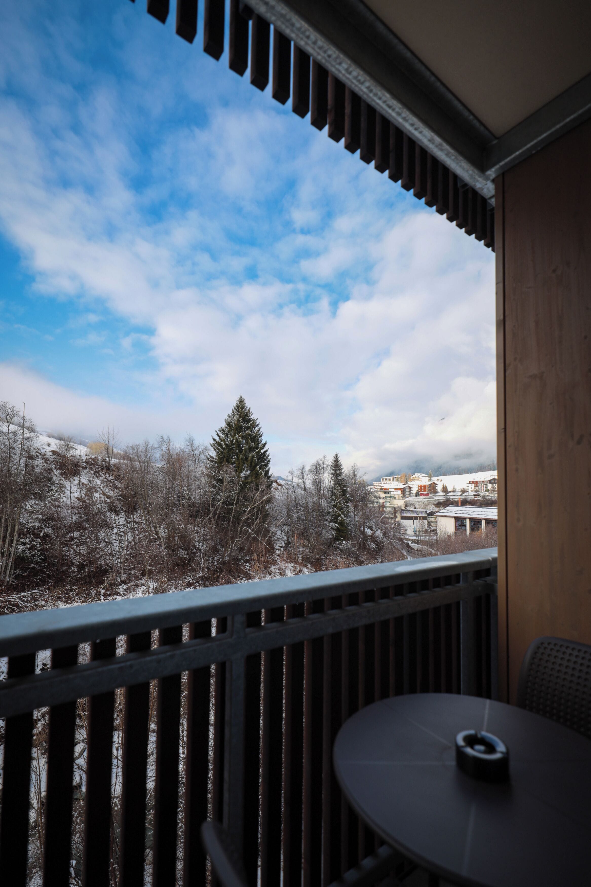 A balcony with a view of a snowy landscape and buildings.