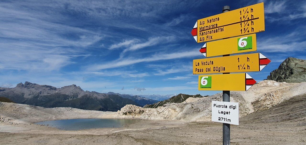 Un panneau indicateur directionnel comportant de nombreuses flèches pointant vers différentes destinations et indiquant la distance respective à parcourir pour chacune.