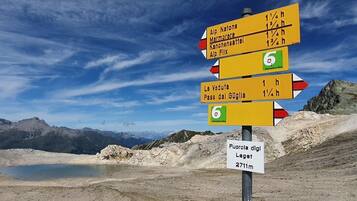 Un panneau indicateur directionnel comportant de nombreuses flèches pointant vers différentes destinations et indiquant la distance respective à parcourir pour chacune.