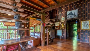 Un'accogliente interno in legno con una scala in legno, un divano e un tavolo da pranzo.