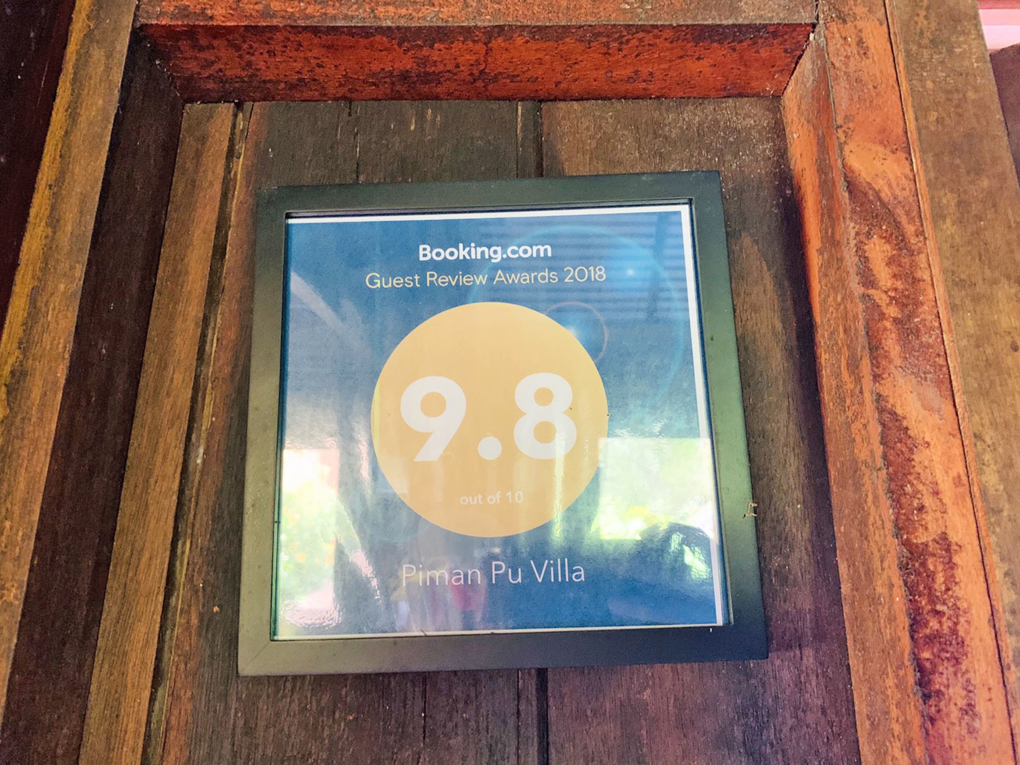 A framed guest review award plaque for Piman Pu Villa with a 9.8 rating out of 10.
