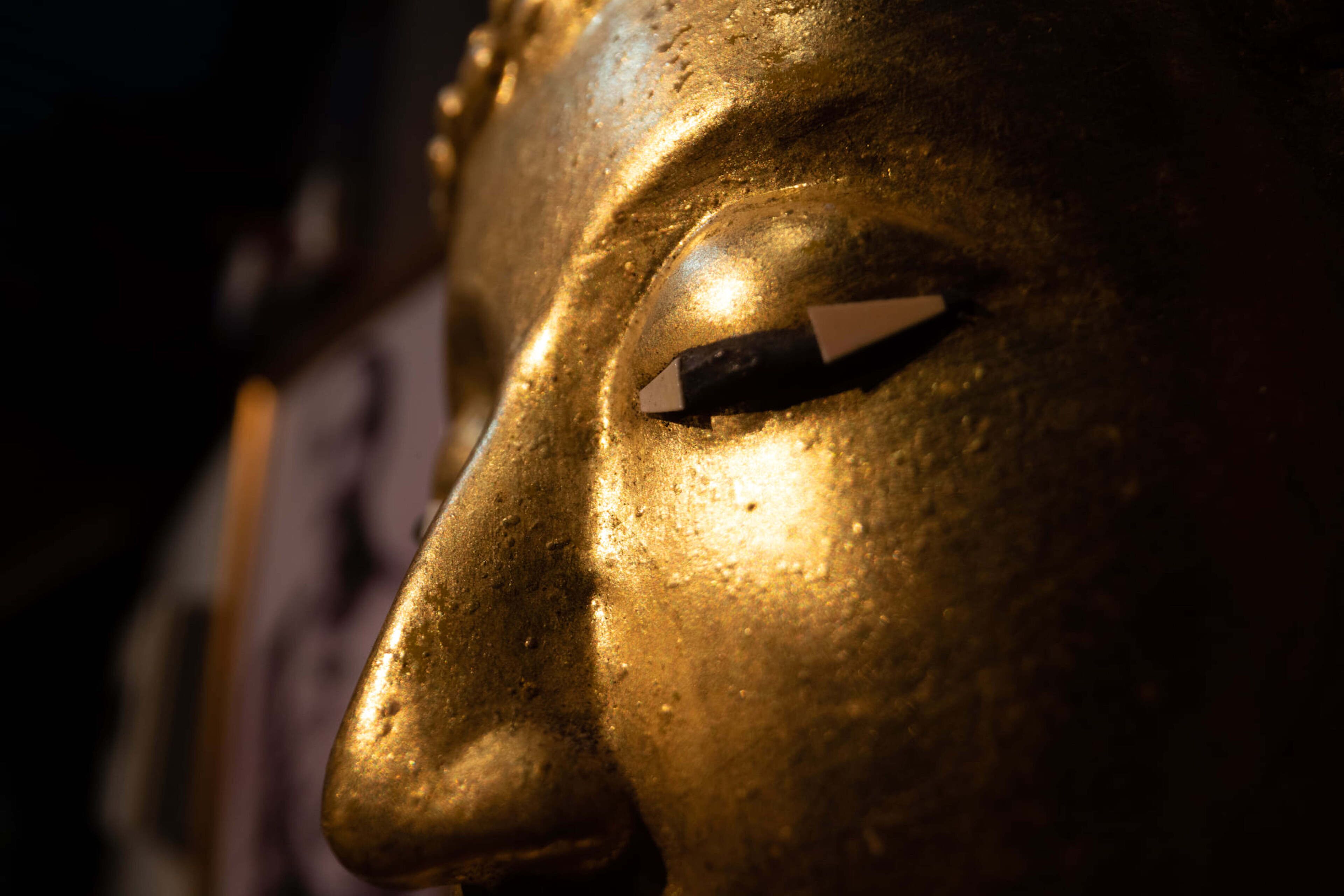 A close-up of a golden statue with a triangular eye design.
