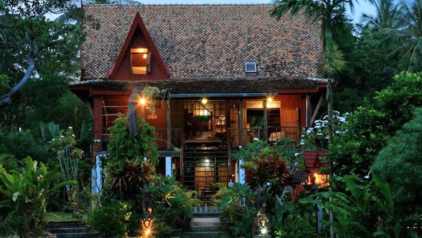 Una casa tradizionale con tetto in tegole, un portico e una piscina.