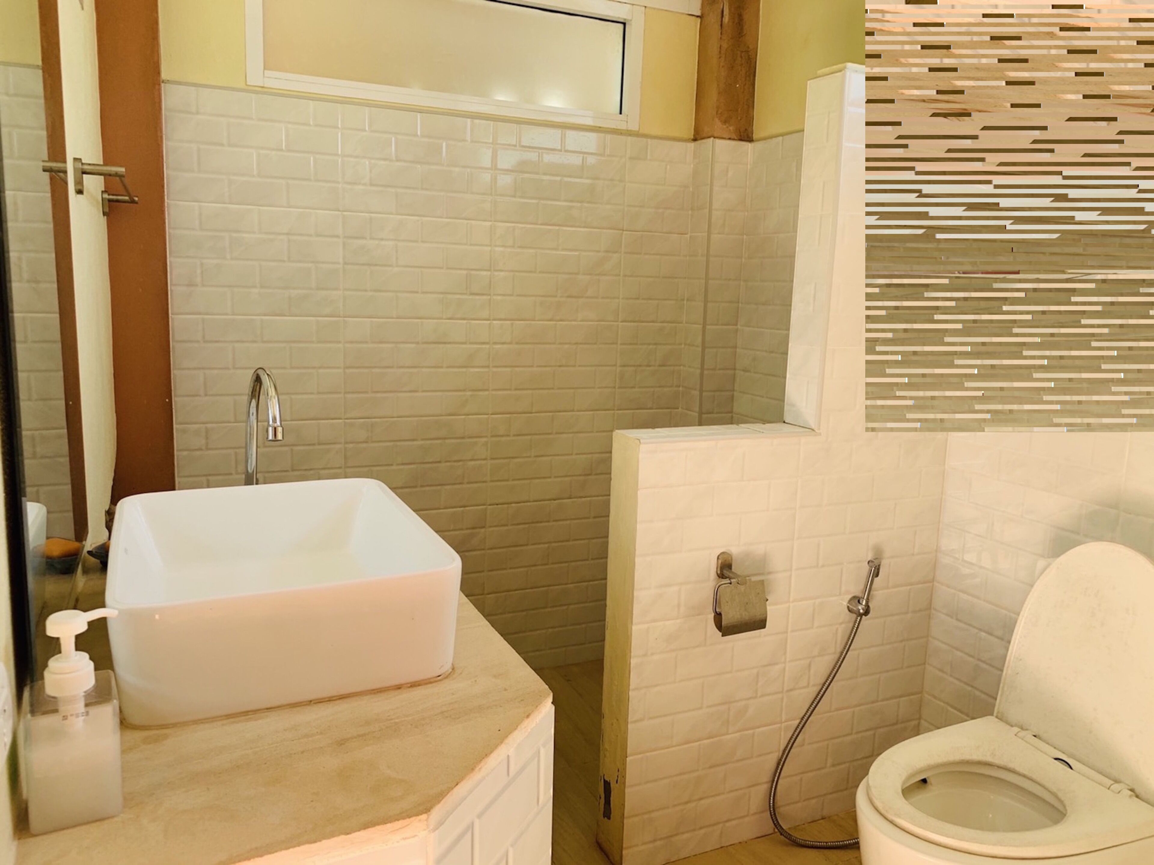 Een badkamer met een wit wastafelmeubel, toilet en douchehoek.