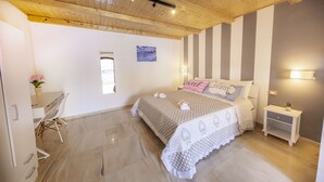 Een slaapkamer met een bed, nachtkastjes, een bureau en een stoel.