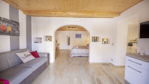 Een moderne woonkamer met een bank, een eethoek en een keuken.