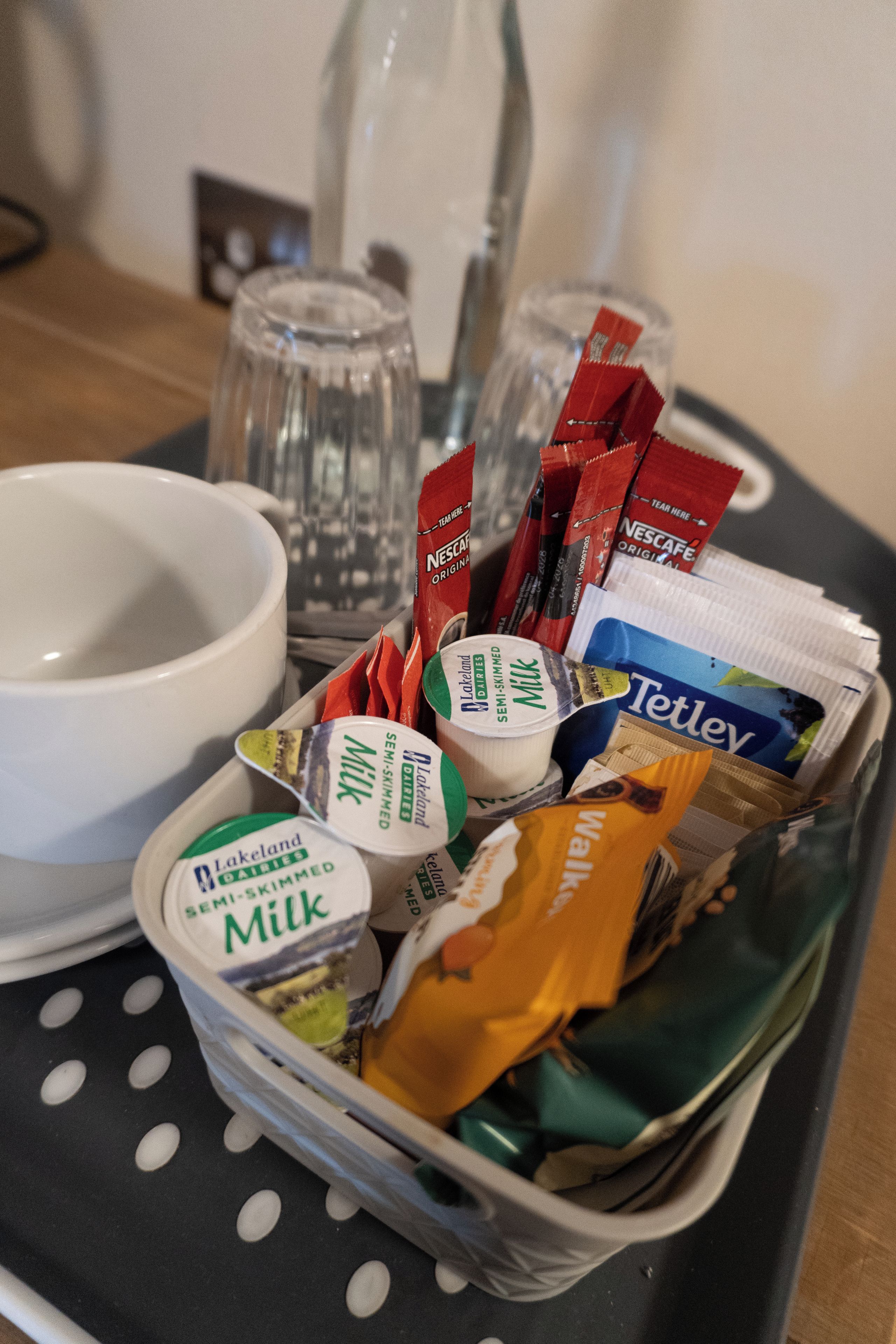 Una bandeja con diversos alimentos, incluyendo leche, queso y aperitivos.