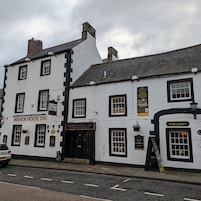 Un edificio tradicional con un letrero que indica Manor House Inn y el Restaurante Griffin Room.