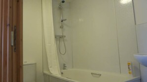A bathroom with a bathtub, shower, and toilet. - Manor House Inn (Haltwhistle)
