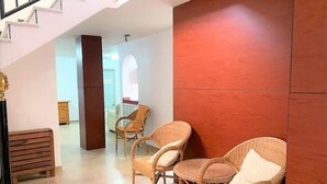 A modern interior with wicker furniture, a staircase, and a red accent wall. - Bright Villa 20mtrs from the sea (Comunidad Valenciana)