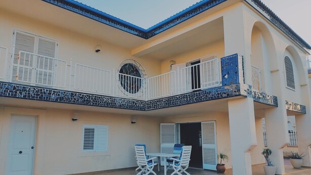 A two-story building with a tiled balcony, white shutters, and a tiled floor. - Bright Villa 20mtrs from the sea (Comunidad Valenciana)