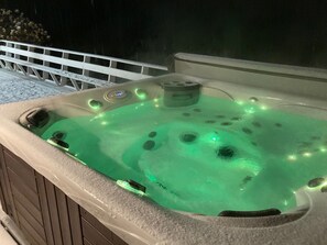 Un jacuzzi con panel de control y barandilla blanca.