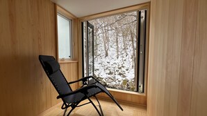 Una habitación con paredes de madera y un ventanal grande.