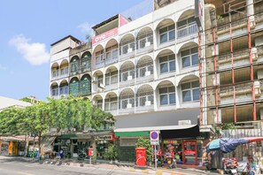 A multi-story building with balconies, a storefront, and a no parking sign.